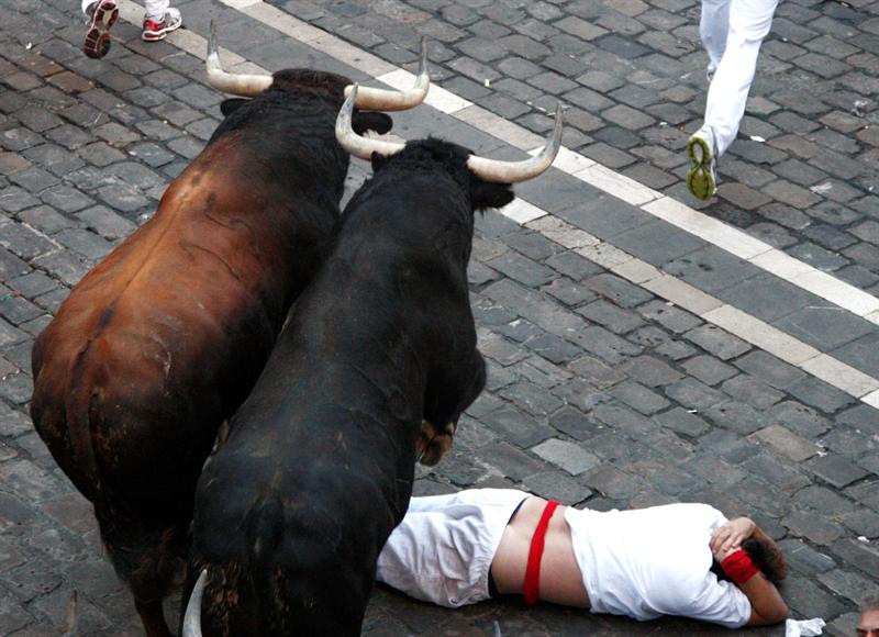 Dos toros pasan por encima de un mozo. Foto: EFE